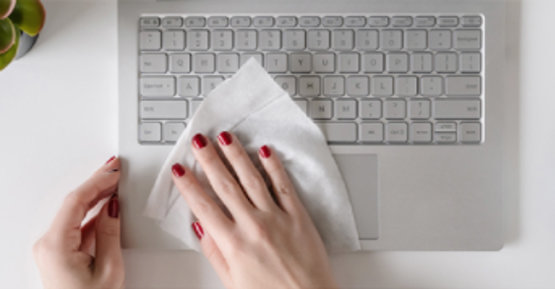 Womans hand wiping keyboard
